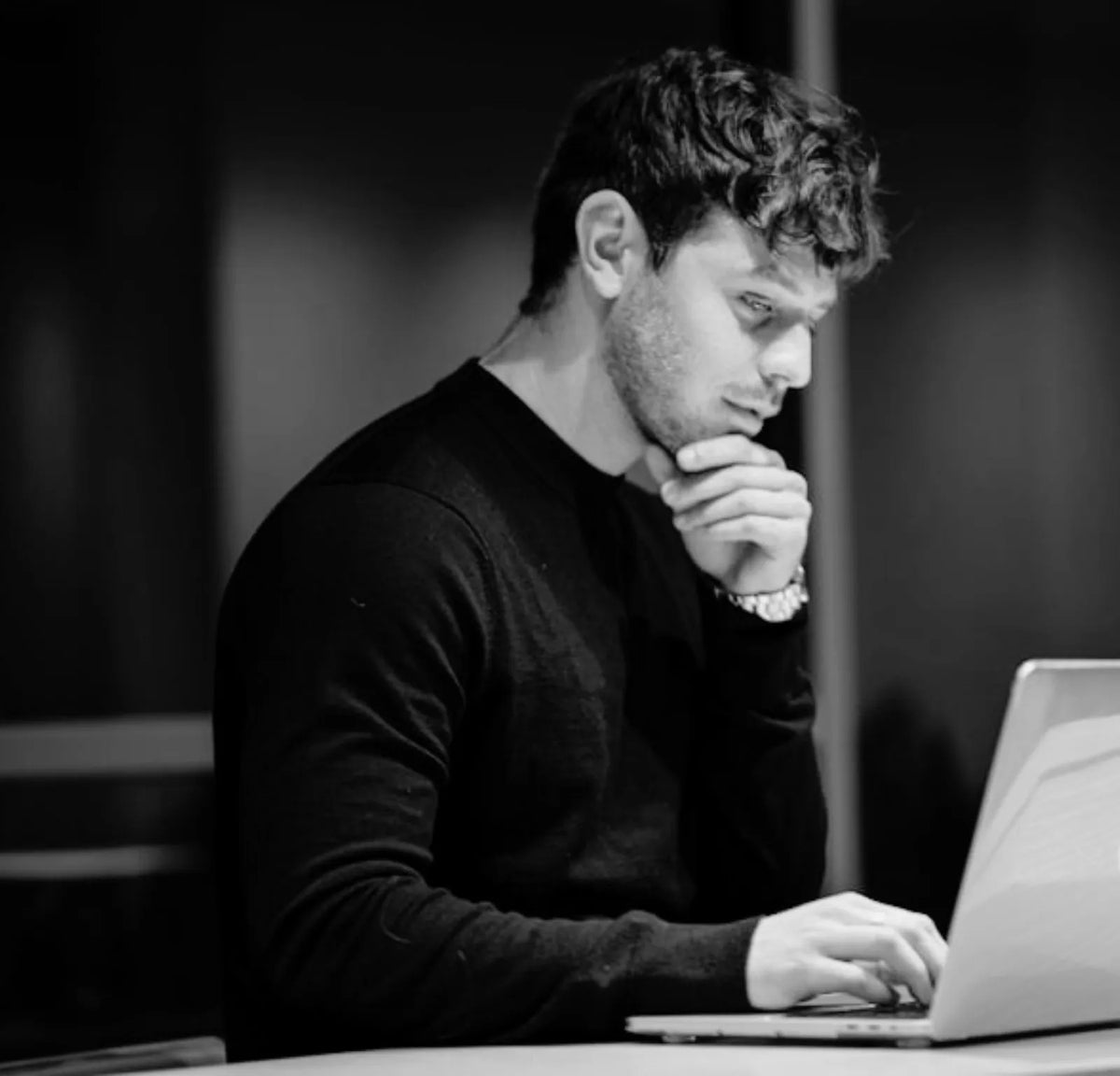 Nachdenkliche Person bei konzentrierter Arbeit am Laptop